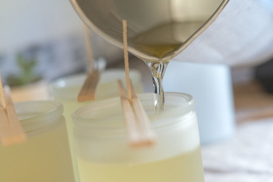 Image of wax being poured into a frosted glass vessel
